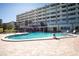 Community pool with lounge chairs and a building in the background at 100 Bluff View Dr # 409C, Belleair Bluffs, FL 33770