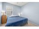 Cozy bedroom with blue walls, neutral carpet, and natural light from the window at 11009 Silver Dancer Dr, Riverview, FL 33579