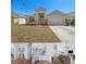 Charming single-story home boasts a manicured lawn and two-car garage, complemented by lush landscaping at 11009 Silver Dancer Dr, Riverview, FL 33579
