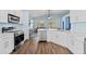 A modern kitchen with stainless steel appliances, white cabinetry, and an eat-in bar at 11009 Silver Dancer Dr, Riverview, FL 33579