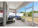 Screened in patio with blue cushioned outdoor furniture and nice landscaping at 11009 Silver Dancer Dr, Riverview, FL 33579