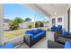 Screened in patio with blue cushioned outdoor furniture and nice landscaping at 11009 Silver Dancer Dr, Riverview, FL 33579