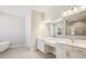 Well-lit bathroom featuring a soaking tub, double sink vanity, and large mirror at 12817 Daleridge Pl, Riverview, FL 33579