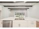 Modern kitchen featuring an island, stainless steel dishwasher, white cabinets, and wood beam ceiling at 12817 Daleridge Pl, Riverview, FL 33579