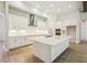 Bright, spacious kitchen featuring white cabinets, stainless steel appliances, and a large island with quartz countertops at 12817 Daleridge Pl, Riverview, FL 33579