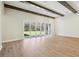 Bright and airy living room with wood-look floors, wood beam ceilings, and access to the outdoor patio at 12817 Daleridge Pl, Riverview, FL 33579