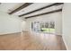 Bright living room features wood-look floors, wood beam ceilings, and sliding doors to the backyard at 12817 Daleridge Pl, Riverview, FL 33579