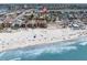 Aerial view showcasing the property's location on a sandy beach near a bustling city and waterway at 129 94Th Ave, Treasure Island, FL 33706
