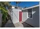 View of exterior including access doors and storage areas, surrounded by lush tropical landscaping at 129 94Th Ave, Treasure Island, FL 33706