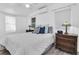 Bright bedroom featuring white walls, wood floors, ceiling fan and natural light from dual windows at 129 94Th Ave, Treasure Island, FL 33706