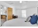 Comfortable bedroom with a white comforter, blue decorative pillows and a glimpse of the kitchen at 129 94Th Ave, Treasure Island, FL 33706
