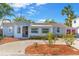 Charming single-story home featuring a well-manicured front yard, light gray exterior, and brick accents around the entry at 129 94Th Ave, Treasure Island, FL 33706