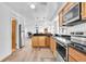 Open kitchen with stainless steel appliances, light wood cabinets, and a view into the adjacent living area at 129 94Th Ave, Treasure Island, FL 33706