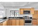 Bright kitchen featuring stainless steel appliances, granite countertops, and light wood cabinetry at 129 94Th Ave, Treasure Island, FL 33706