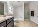 Bright bathroom featuring a soaking tub, glass-enclosed shower, tile floors, and modern vanity with dark cabinets at 14916 Imperial Purple Ln, Wimauma, FL 33598