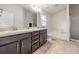 Bright bathroom features double vanity, soaking tub, and walk-in shower at 14916 Imperial Purple Ln, Wimauma, FL 33598