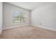 Bright bedroom featuring neutral carpeting and a large window that is bringing in plenty of sunlight at 14916 Imperial Purple Ln, Wimauma, FL 33598