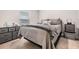 Comfortable bedroom featuring a bed with a gray comforter, side tables, and a storage dresser at 14916 Imperial Purple Ln, Wimauma, FL 33598