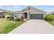Beautiful one-story home featuring well-maintained landscaping, a two-car garage, and a welcoming entrance at 14916 Imperial Purple Ln, Wimauma, FL 33598