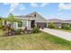 Charming one-story home with a well-manicured lawn, beautiful landscaping, and a two-car garage at 14916 Imperial Purple Ln, Wimauma, FL 33598