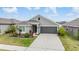 Charming single-story home with manicured lawn, beautiful landscaping, and a two-car garage at 14916 Imperial Purple Ln, Wimauma, FL 33598