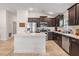 Bright kitchen features stainless appliances, dark cabinetry, island and tile flooring at 14916 Imperial Purple Ln, Wimauma, FL 33598