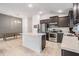 Bright kitchen features stainless appliances, dark cabinetry, island and tile flooring at 14916 Imperial Purple Ln, Wimauma, FL 33598