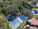 Aerial view of home showcasing pool, tennis court, and mature trees at 1908 Bayshore Ct, Safety Harbor, FL 34695