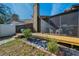 Backyard with screened porch, hot tub, landscaping, and a wood-burning chimney at 1908 Bayshore Ct, Safety Harbor, FL 34695