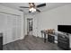 Bedroom featuring wood-look flooring, ceiling fan, closet, and a computer desk at 1908 Bayshore Ct, Safety Harbor, FL 34695