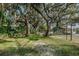 Beautiful community park featuring lush greenery, mature trees draped with Spanish moss, and a chain-link fence enclosed tennis court at 1908 Bayshore Ct, Safety Harbor, FL 34695