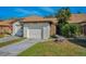 Charming home featuring an attached one-car garage and well-maintained lawn at 1908 Bayshore Ct, Safety Harbor, FL 34695