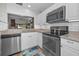 Kitchen with stainless steel appliances and light countertops adjacent to an open living space at 1908 Bayshore Ct, Safety Harbor, FL 34695
