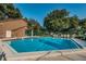 Community pool view on a sunny day includes lounge chairs, fenced perimeter and bath house at 1908 Bayshore Ct, Safety Harbor, FL 34695