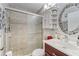 Bright bathroom featuring tiled shower and decorative mosaic mirror at 1908 Dartford Ct, Valrico, FL 33594