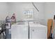 Efficient laundry area with modern appliances and natural light from a window at 19445 Wildwood Dr, Brooksville, FL 34601