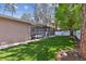 Beautiful backyard featuring green artificial grass, mature trees, and screened-in pool area at 3034 Gull Pl, Clearwater, FL 33762