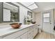 Bathroom featuring double bowl sinks, a skylight, and a glass-enclosed shower at 3034 Gull Pl, Clearwater, FL 33762