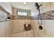 Stylish shower stall with mosaic tiles, bench, and a hand-held showerhead at 3034 Gull Pl, Clearwater, FL 33762