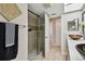 Modern bathroom with glass-enclosed shower, skylight, and double sink vanity at 3034 Gull Pl, Clearwater, FL 33762