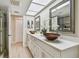 Bathroom featuring double bowl sinks, a skylight, and an open door to the shower at 3034 Gull Pl, Clearwater, FL 33762