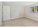 Bedroom features neutral walls, light wood floors, and a large window at 3034 Gull Pl, Clearwater, FL 33762