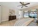 Bright bedroom with light wood flooring and sliders to an enclosed patio and pool at 3034 Gull Pl, Clearwater, FL 33762