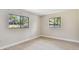 A spacious room with two windows and light wood floors at 3034 Gull Pl, Clearwater, FL 33762
