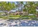 Desirable single-story home boasts a lush green lawn, mature shade trees, and stone facade at 3034 Gull Pl, Clearwater, FL 33762