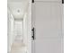 Hallway with a white sliding barn door and multiple white paneled doors leading to bedrooms and other rooms at 3034 Gull Pl, Clearwater, FL 33762