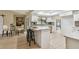 Bright kitchen with white cabinetry, a modern island with seating, and access to outdoor dining for easy entertaining at 3034 Gull Pl, Clearwater, FL 33762