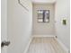 Clean, minimalist laundry room featuring light walls, a window, and hook hangers on the wall at 3034 Gull Pl, Clearwater, FL 33762