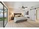 Beautiful bedroom with light wood floors, large slider to the patio, and barn door to en-suite at 3034 Gull Pl, Clearwater, FL 33762