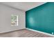 Bedroom with teal accent wall, laminate flooring, and natural light from the window at 3101 N 15Th St, Tampa, FL 33605